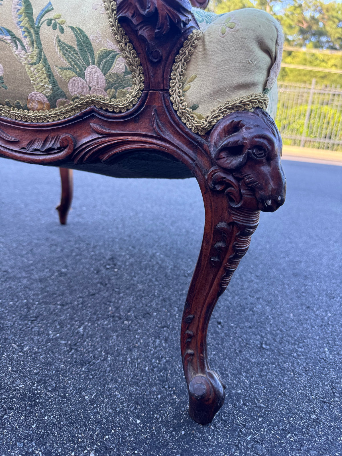 Full cabriole leg showing the ram's head at the knee and the fleece carved as a pendant trail running down to a scrolled toe