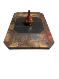 Slate tile coffee table with multicolor stone top and black center tiles, shown in front of a fireplace on an area rug