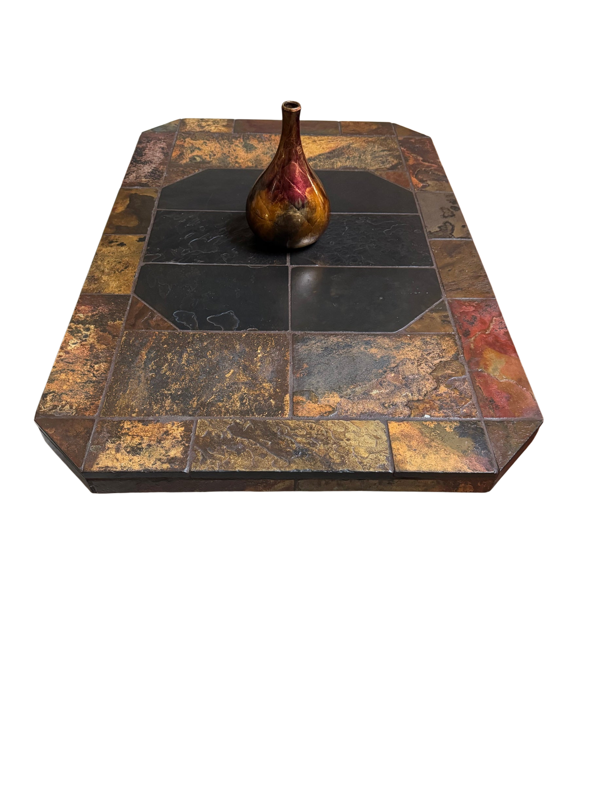 Slate tile coffee table with multicolor stone top and black center tiles, shown in front of a fireplace on an area rug