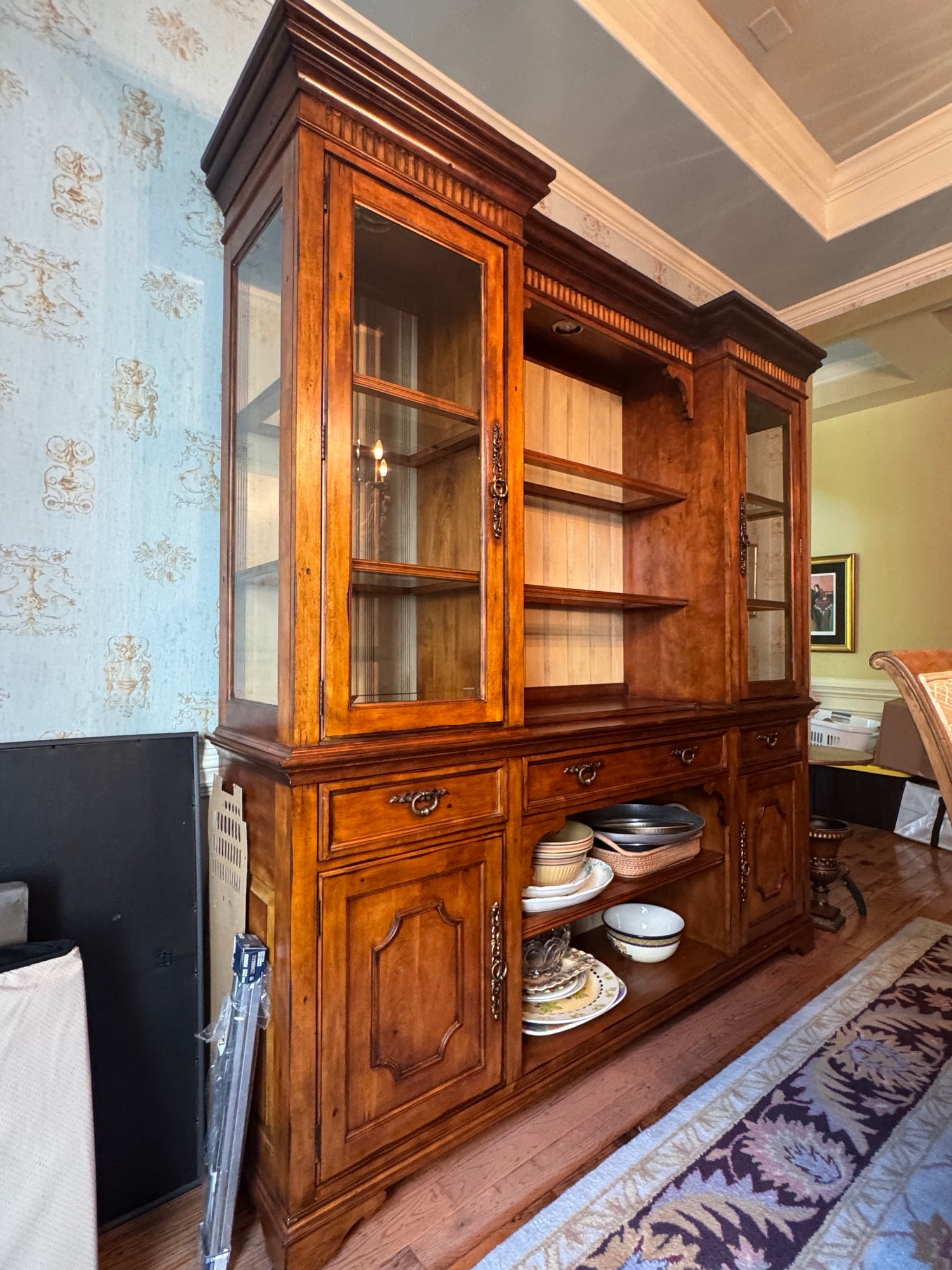 Close-up angle of upper glass doors and open center section with decorative wood grain backing and horizontal shelves