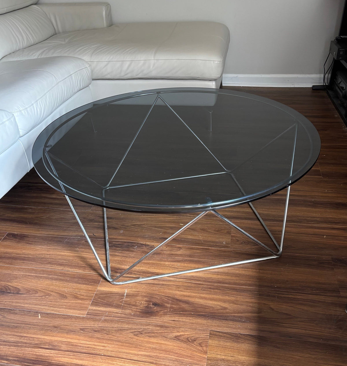 Round glass coffee table from the side in a living room
