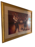 Angled view of a framed sepia-toned print depicting two trumpet players in a jazz club setting, housed in a gilt wood frame with a wide mat and glass front.