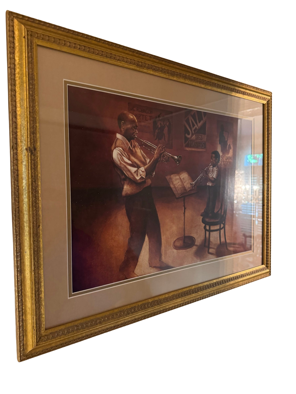 Angled view of a framed sepia-toned print depicting two trumpet players in a jazz club setting, housed in a gilt wood frame with a wide mat and glass front.
