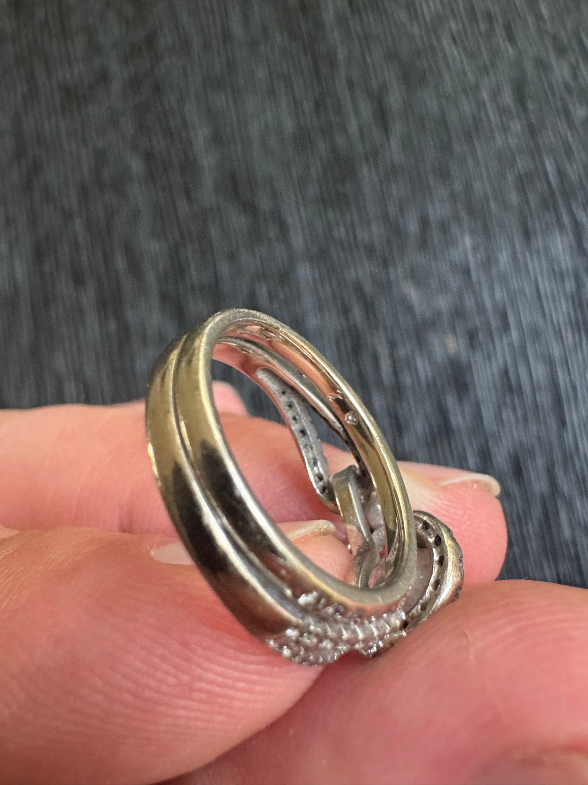 Ring interior side profile in hand, revealing band width and pave setting along shoulder