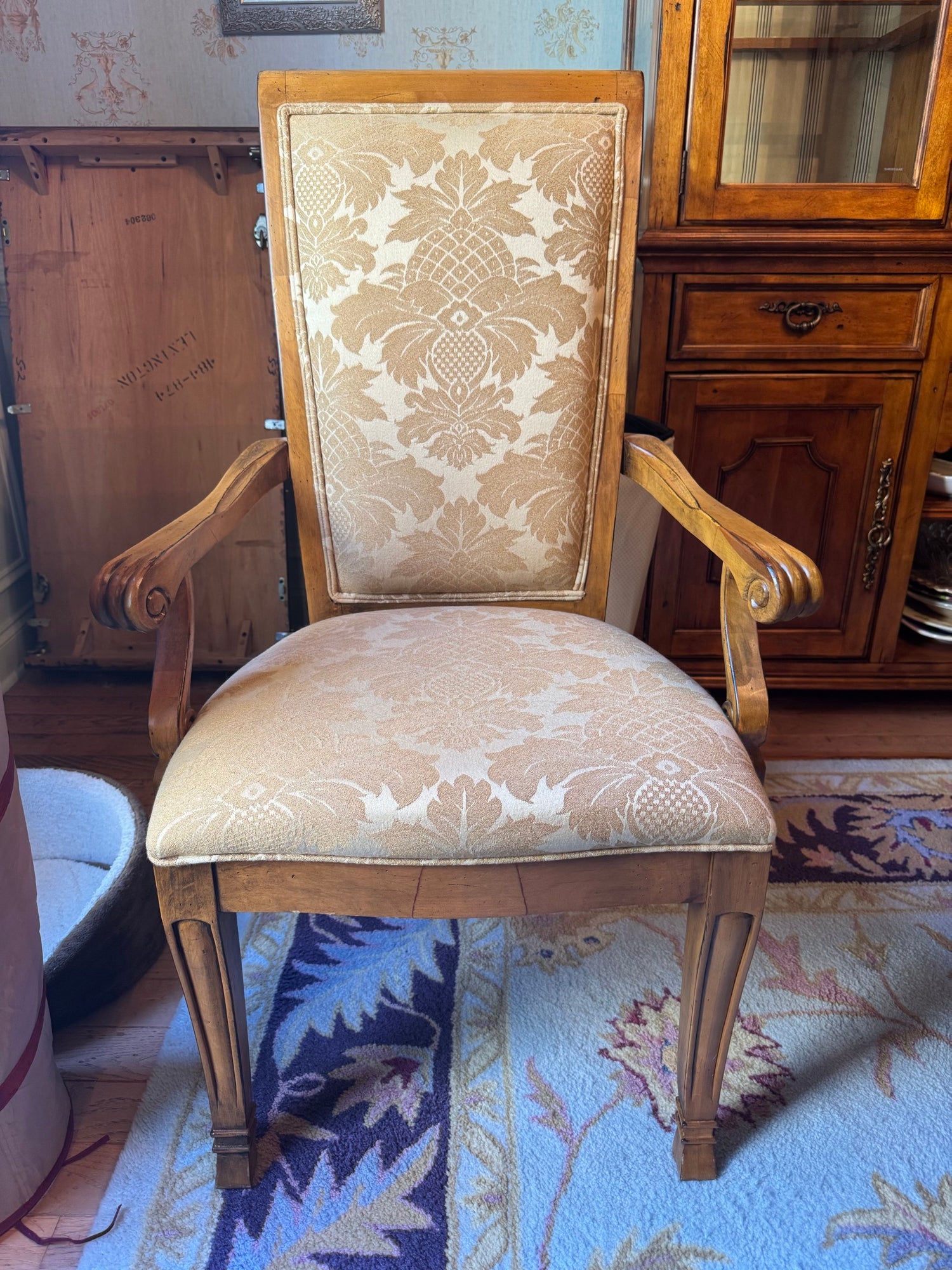 Upholstered dining chair with damask fabric back and seat, carved wooden frame and arms