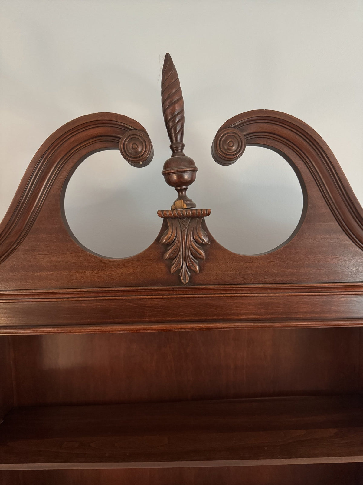 Broken-arch bonnet with flame finial above the glass doors