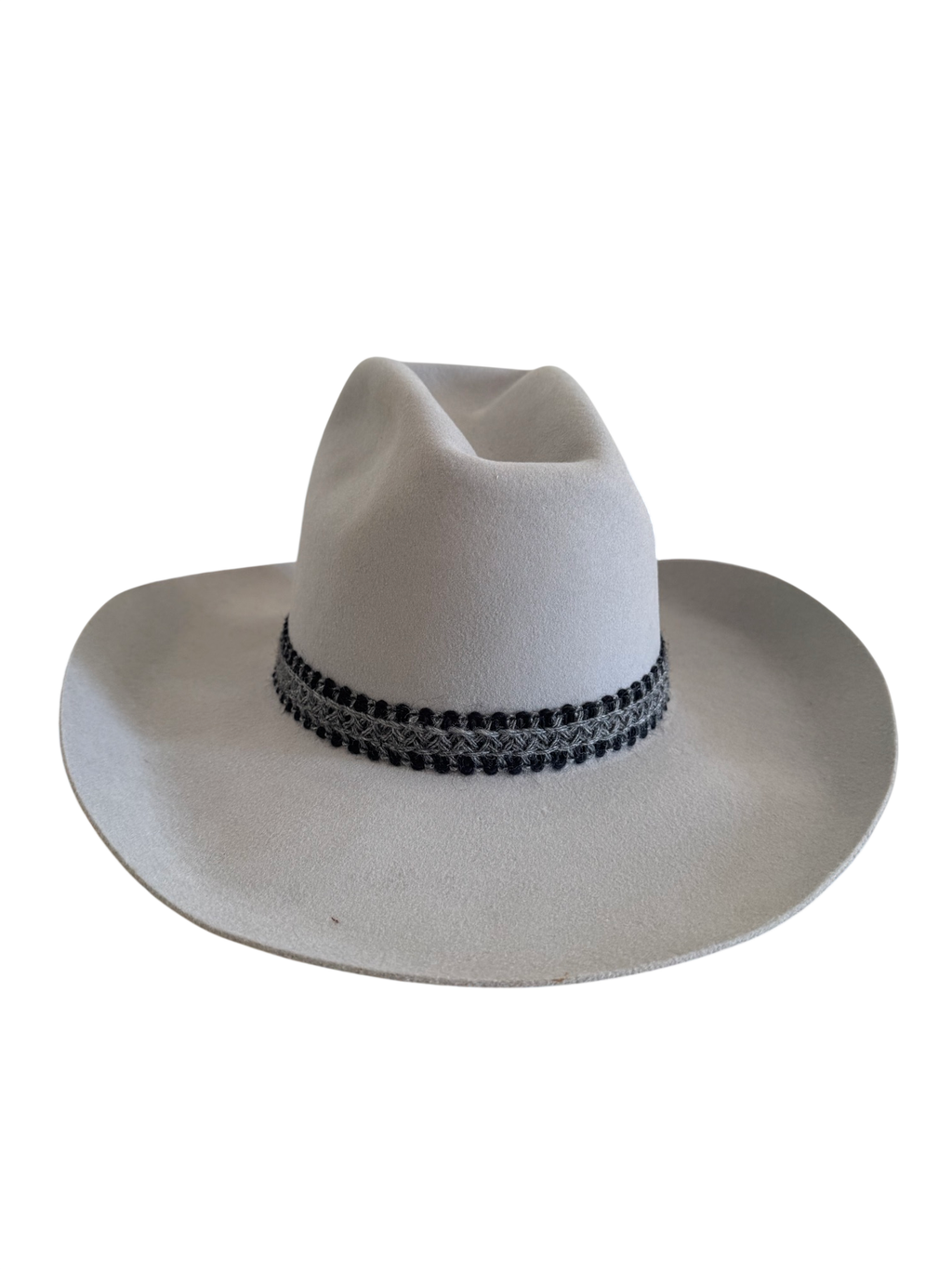 White felt cowboy hat with black decorative band, photographed against white background