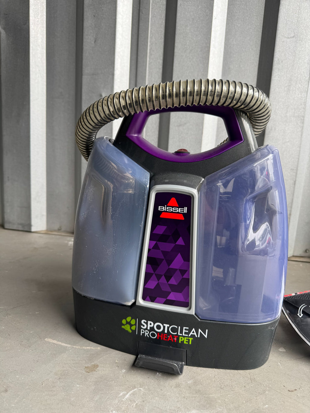 Front-facing view of purple and grey Bissell SpotClean ProHeat Pet cleaner with purple handle and metallic hose
