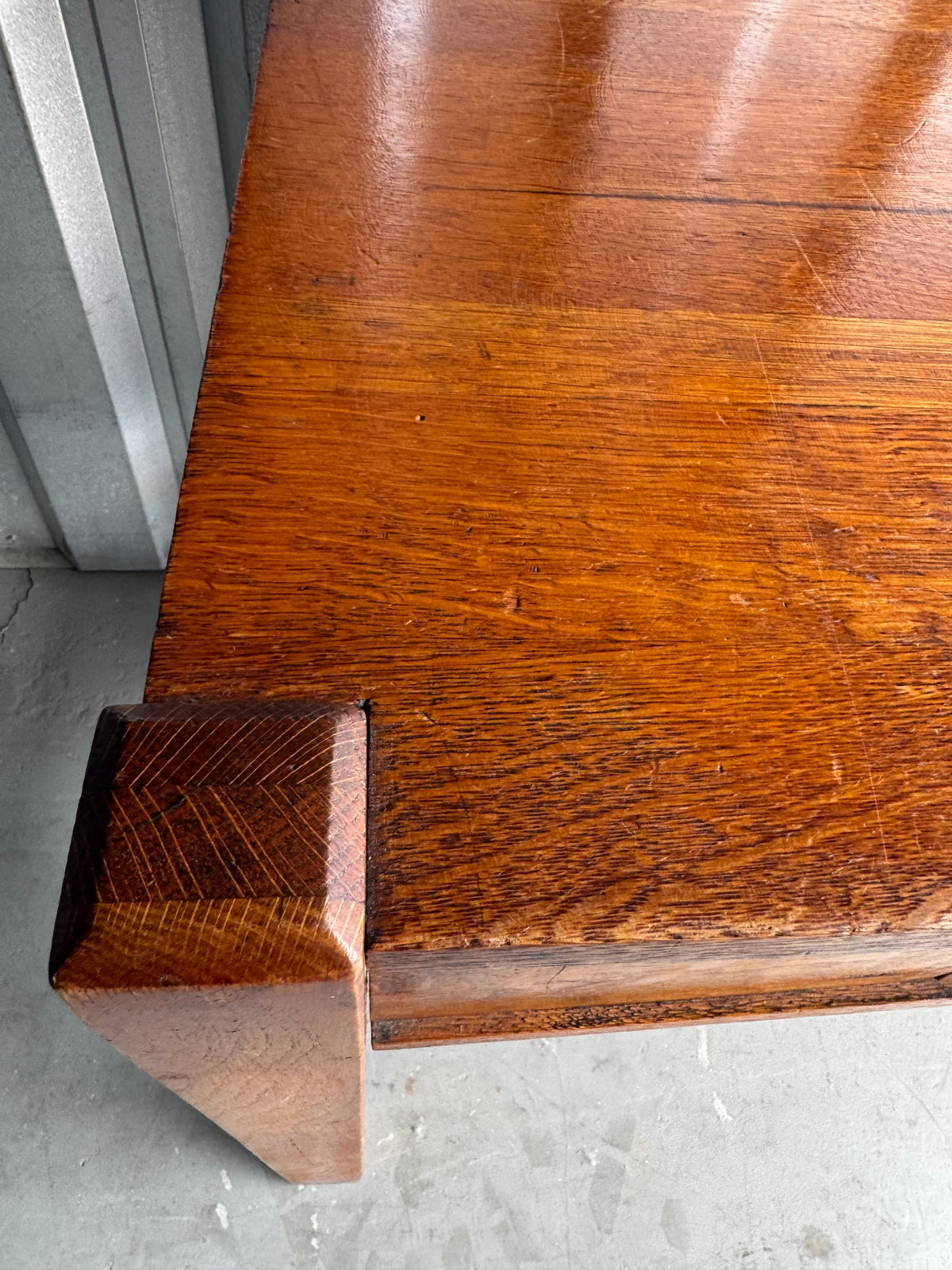 Open drawer interior showing wood construction, metal pull hardware, and accumulated dust and debris