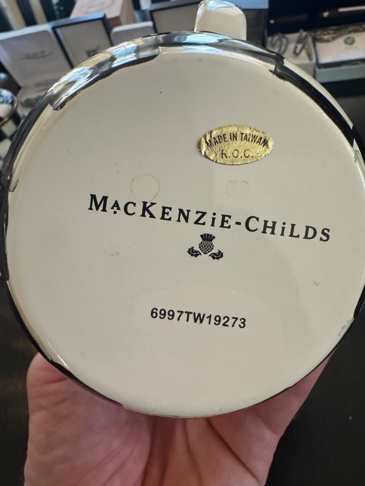 Underside of lidded sugar bowl showing 'MACKENZIE-CHILDS' text, thistle logo, 'MADE IN TAIWAN' mark, and product code '6997TW19273'