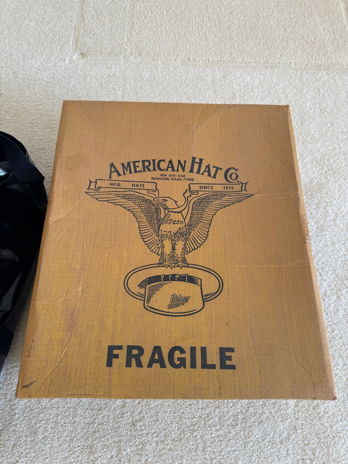 Wooden shipping box with American Hat Co. branding, eagle logo, and 'Fragile' marking