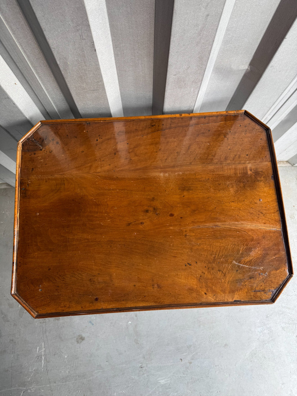 Overhead view of rectangular walnut tabletop with beveled edges and warm honey-brown finish
