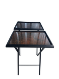 Pair of black metal nesting tables with faux tortoiseshell tops, viewed from front at angle showing both tables stacked
