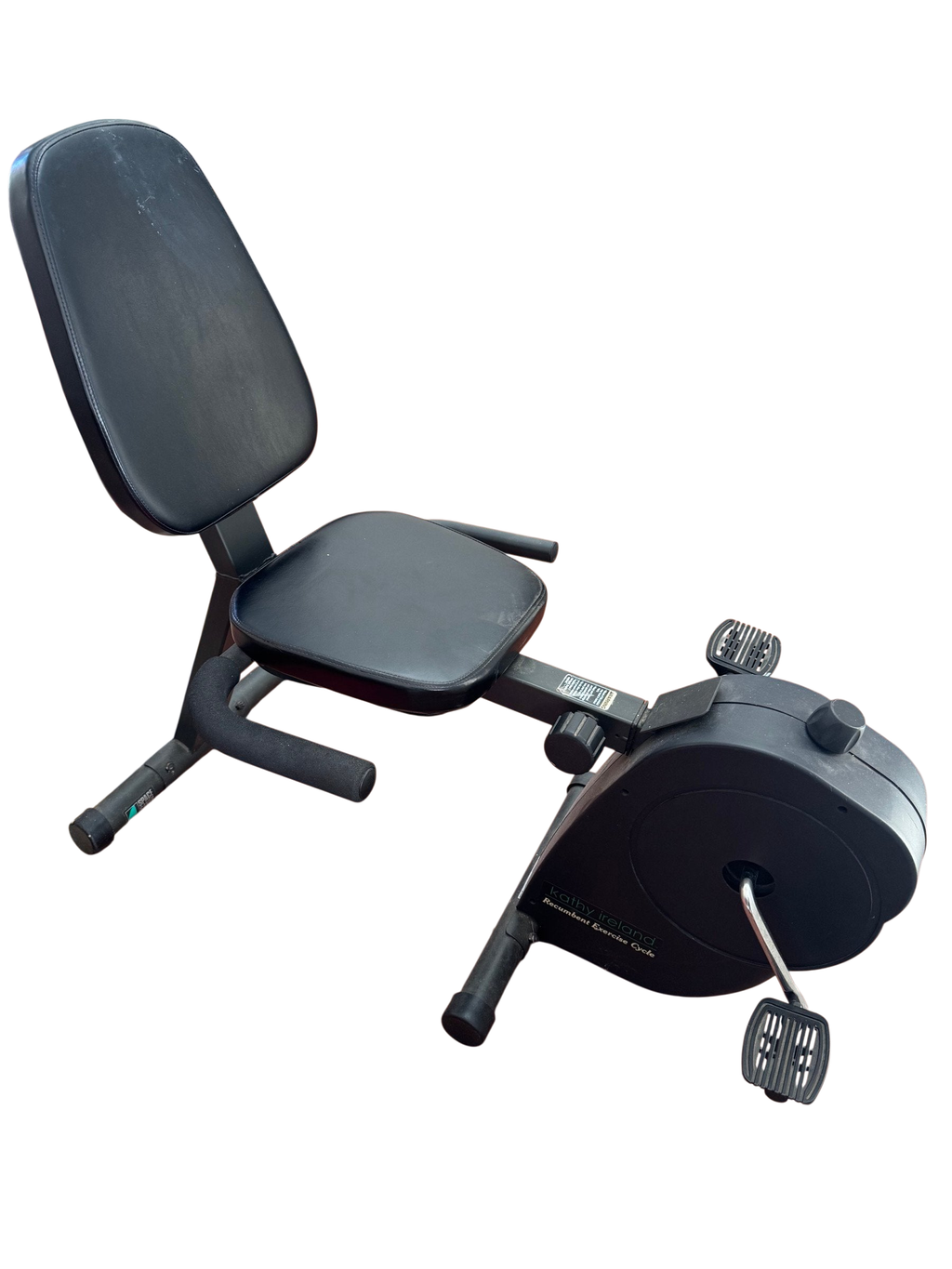 Black recumbent exercise cycle seen from the side on a wood floor