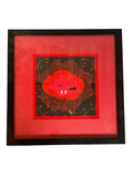 Small framed painting of a smiling red cloud creature on black with a red mat in a black frame, straight-on view