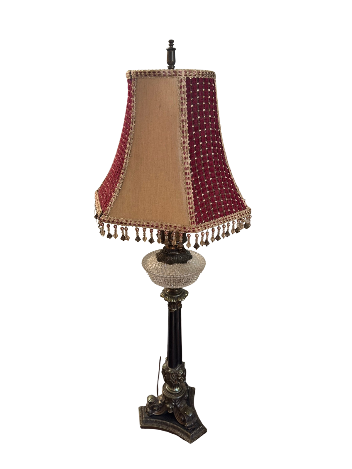 Table lamp with beaded burgundy and tan shade on a glass-top side table