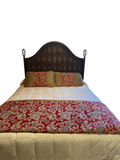 Queen bed with dark carved wooden headboard, cream quilted mattress, red and gold damask bedding, gold pillows in pink bedroom