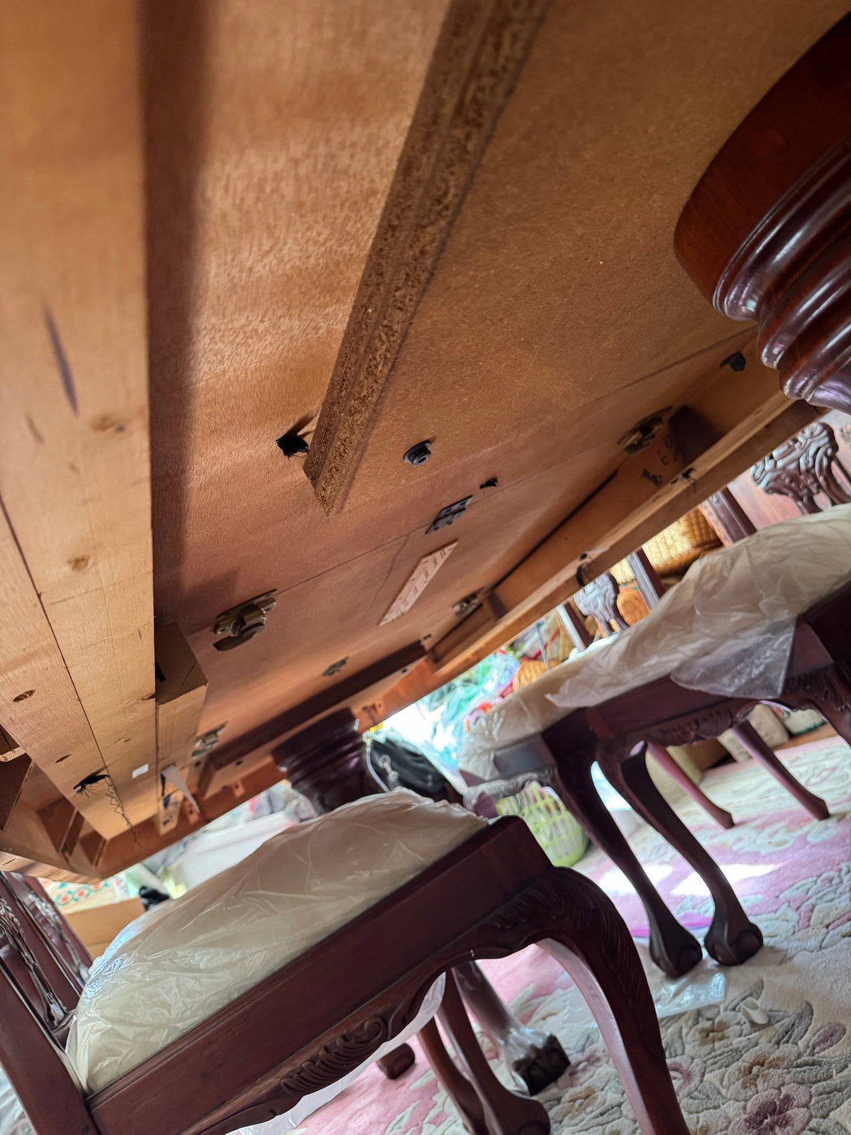 Underside of the table top and a chair in the room