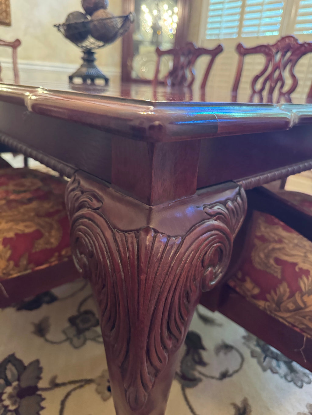 Close-up of a carved cabriole leg and apron on the mahogany dining table