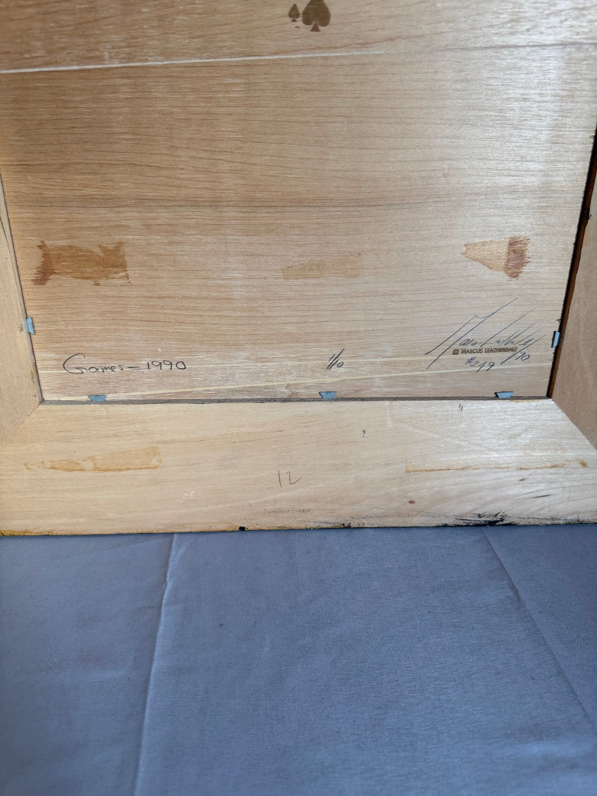 Back of the frame with faint pencil writing and signature