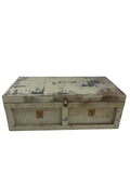 Cream-painted wooden trunk with two gold eagle decals, viewed from front angle, showing distressed finish and metal hardware
