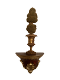 Gilt urn with faux moss topiary displayed on a gold and burgundy wall bracket shelf