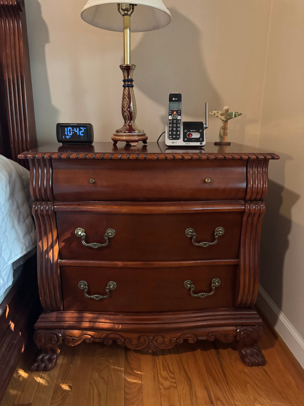 Cherry-finish three-drawer nightstand with carved apron and claw feet