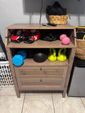 Home gym gear on a wooden cabinet with battle ropes hanging beside it