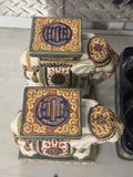 Pair of stacked ceramic elephant garden stools with green tops, gold scrollwork, blue circular medallions, cream bodies with decorative bands