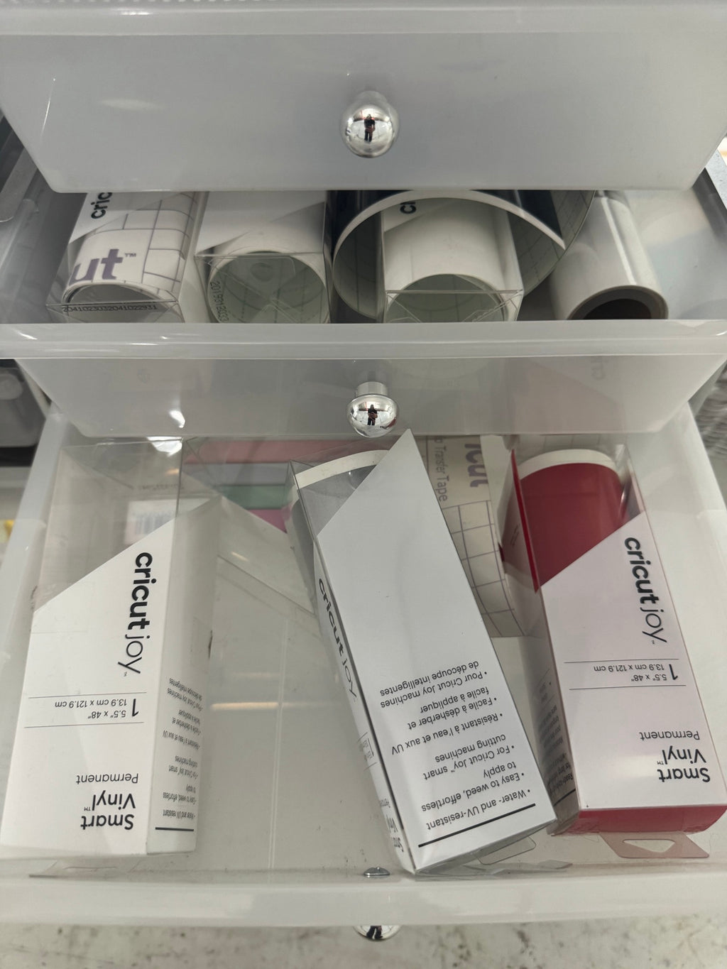 Lower drawer showing various colored vinyl rolls and other cutting supplies organized