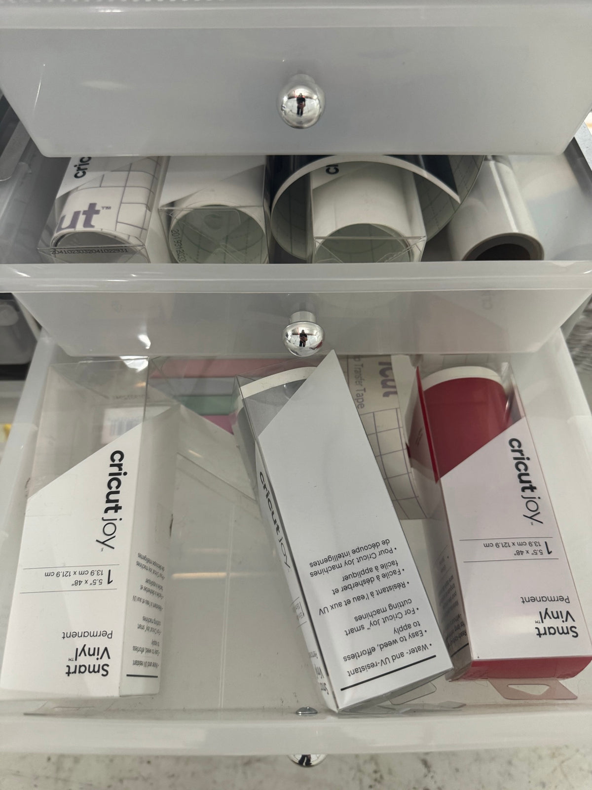 Lower drawer showing various colored vinyl rolls and other cutting supplies organized
