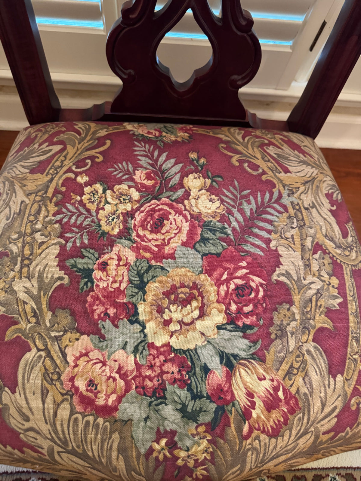Close-up of the carved crest rail and pierced back splat on a dining chair