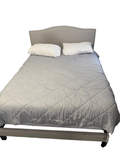 Cream upholstered bed frame with nailhead headboard