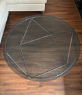 Round glass coffee table with geometric steel rod base, seen from above