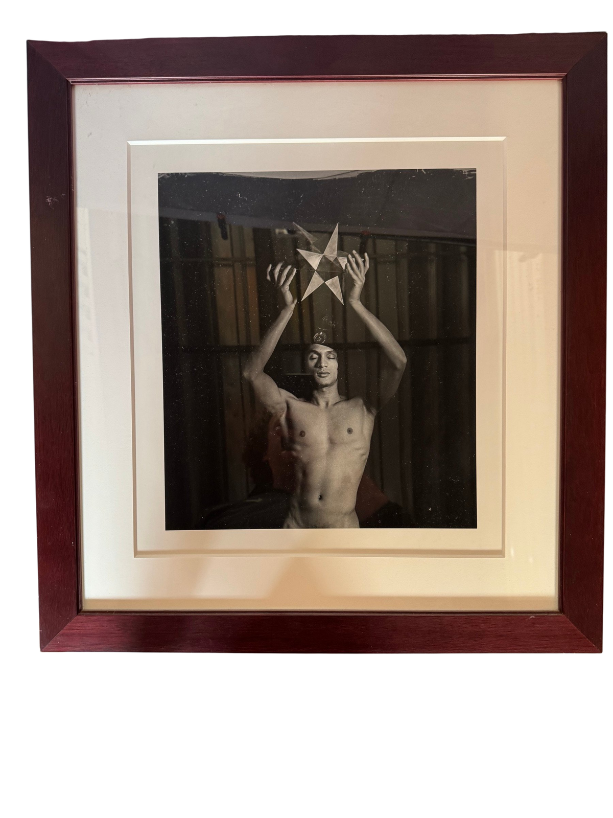 Framed black-and-white photograph of a man holding a star, straight-on