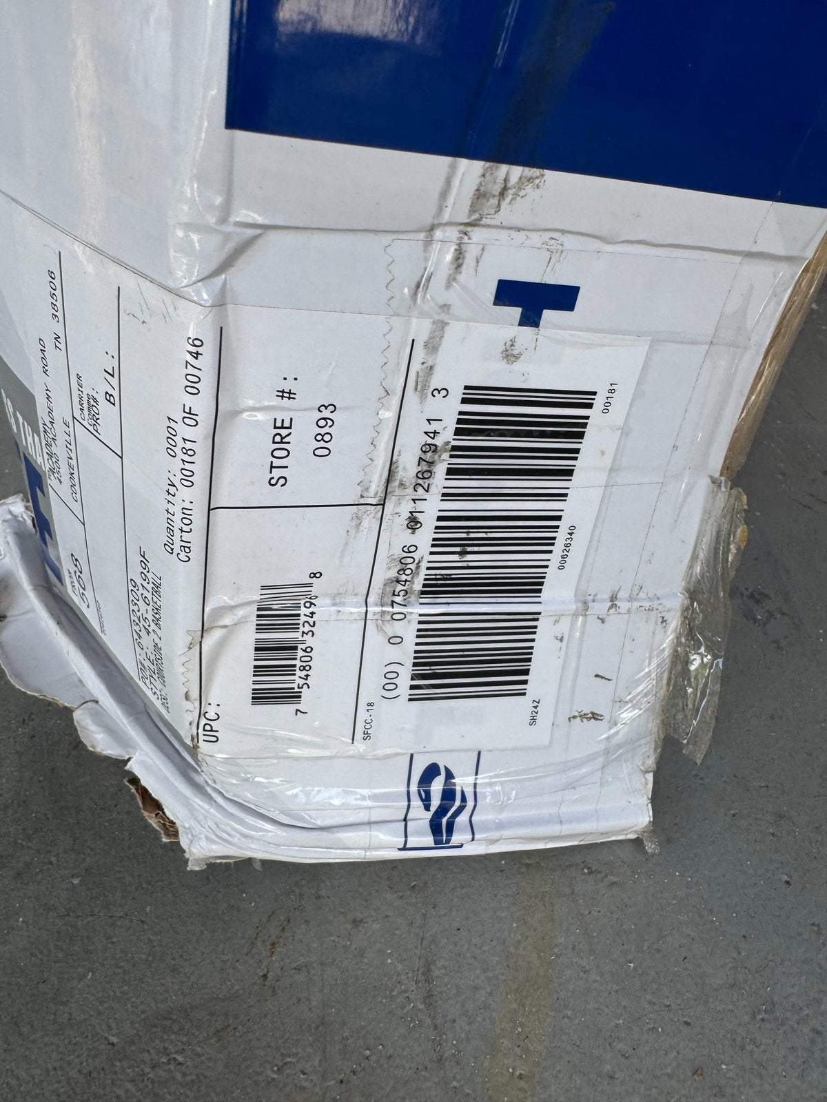 Shipping box label showing barcode, store number 0893, and carrier information on white cardboard packaging