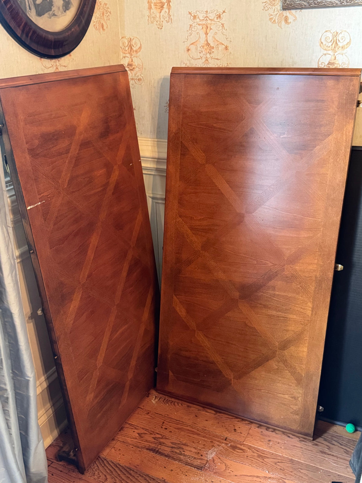 Empty wooden cabinet interior with two vertical panel doors showing figured veneer wood grain