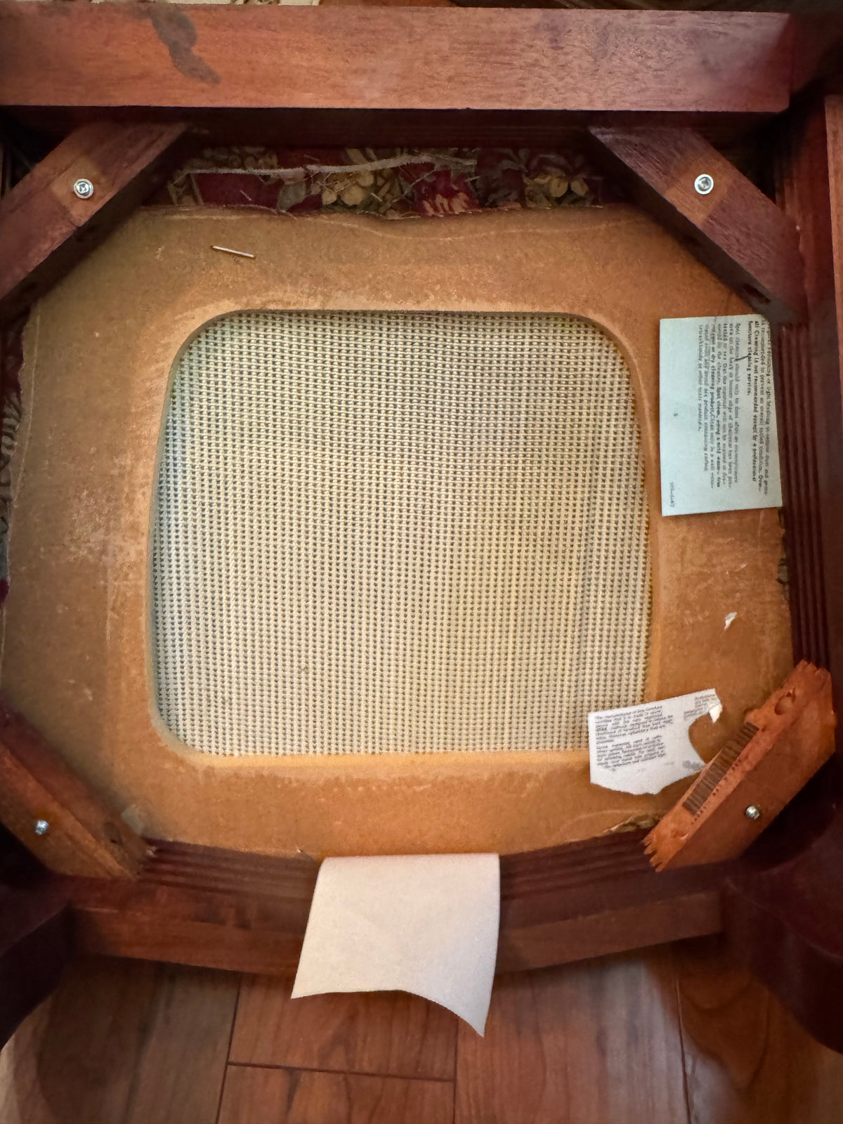 Underside of a dining chair seat showing frame construction and webbing
