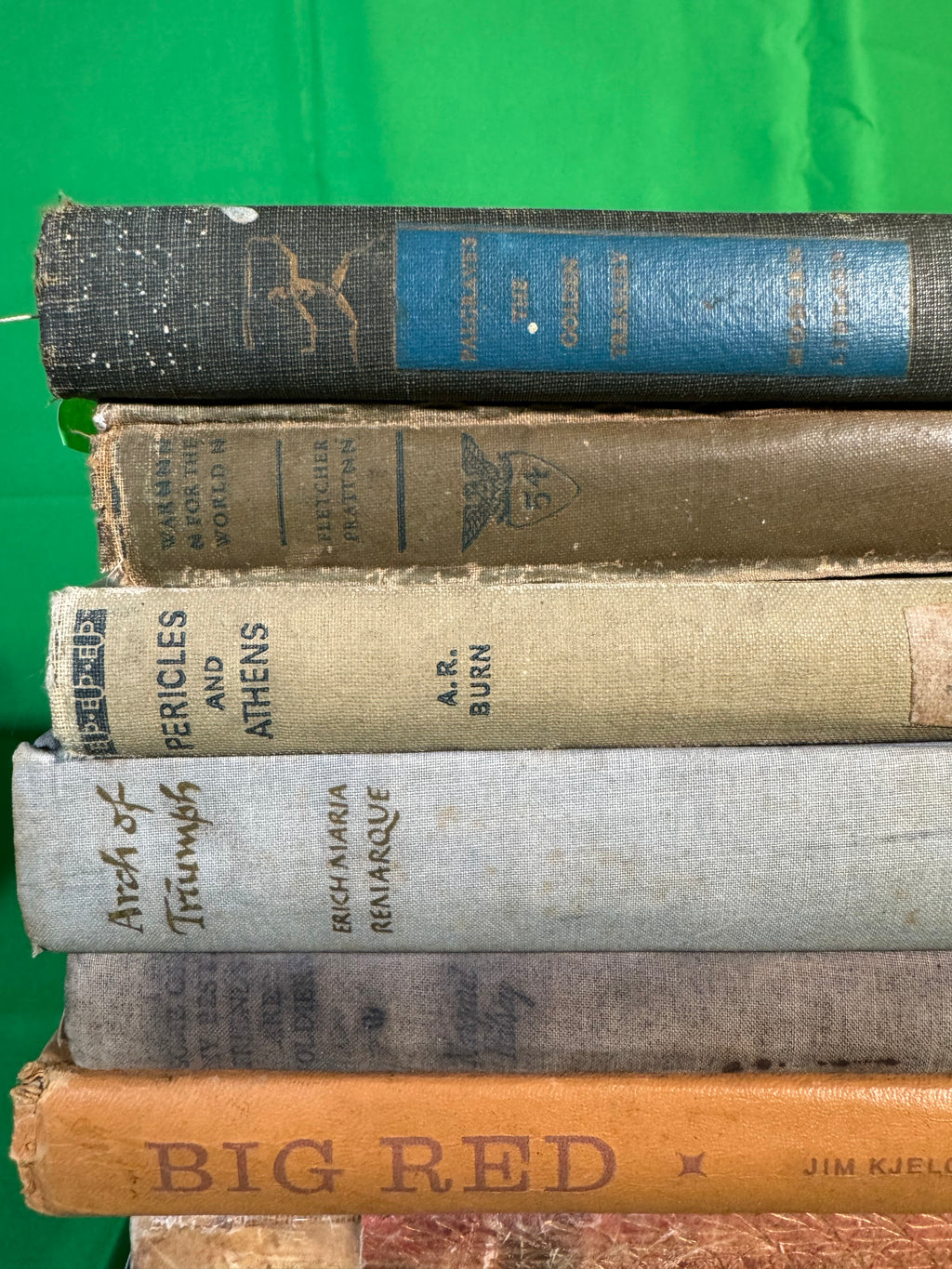 Closer view of the top of a stack of vintage hardcovers: Palgrave's Golden Treasury, War for the World by Fletcher Pratt, Pericles and Athens by A. R. Burn, Arch of Triumph and Big Red