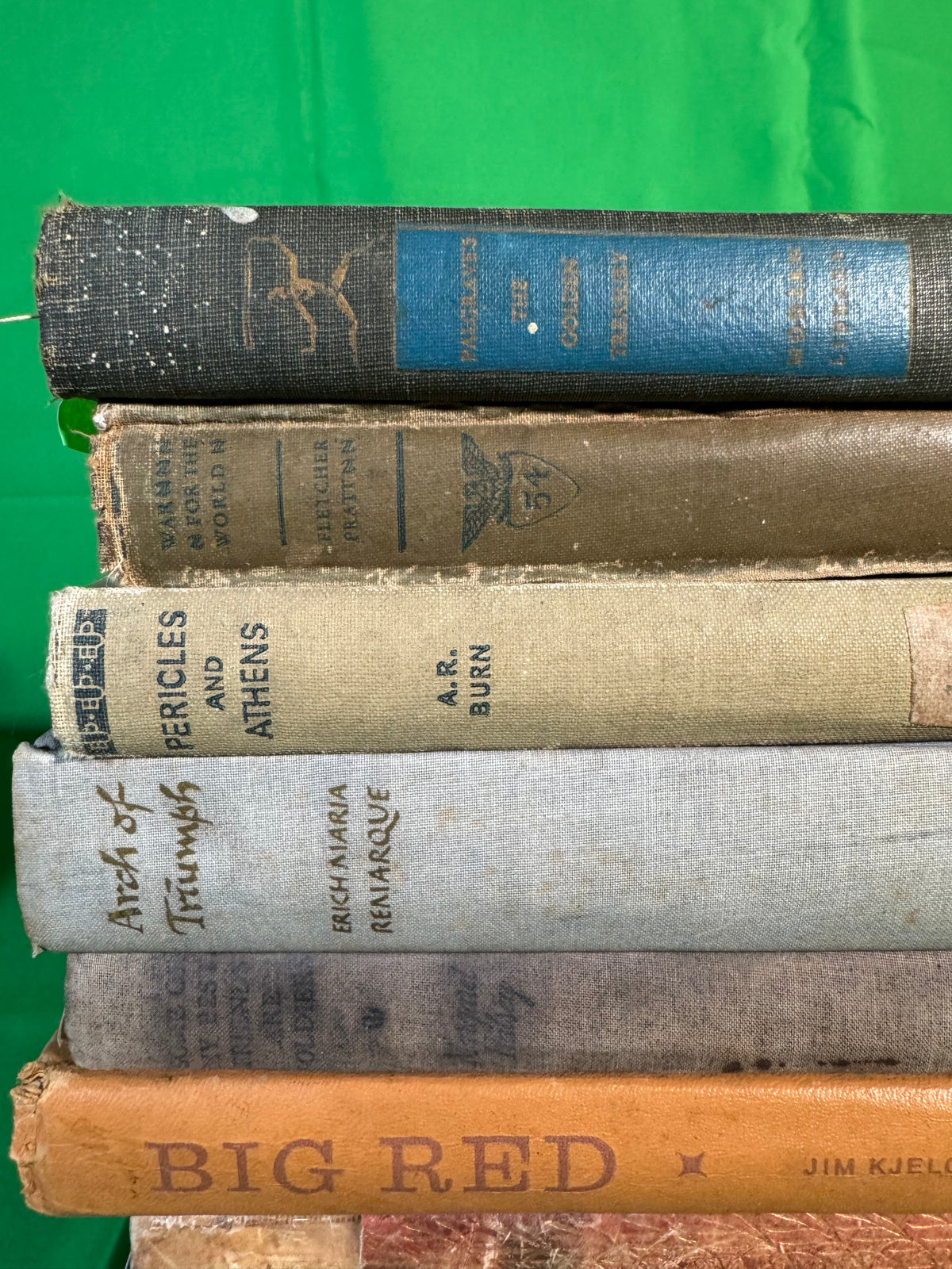 Closer view of the top of a stack of vintage hardcovers: Palgrave's Golden Treasury, War for the World by Fletcher Pratt, Pericles and Athens by A. R. Burn, Arch of Triumph and Big Red