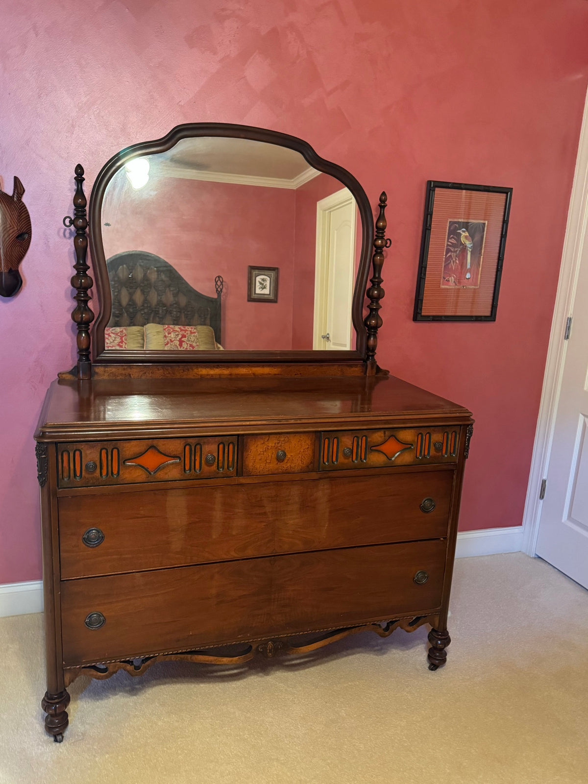 Same dresser from slightly different angle, displaying full front view with arched mirror frame and three-drawer base with casters