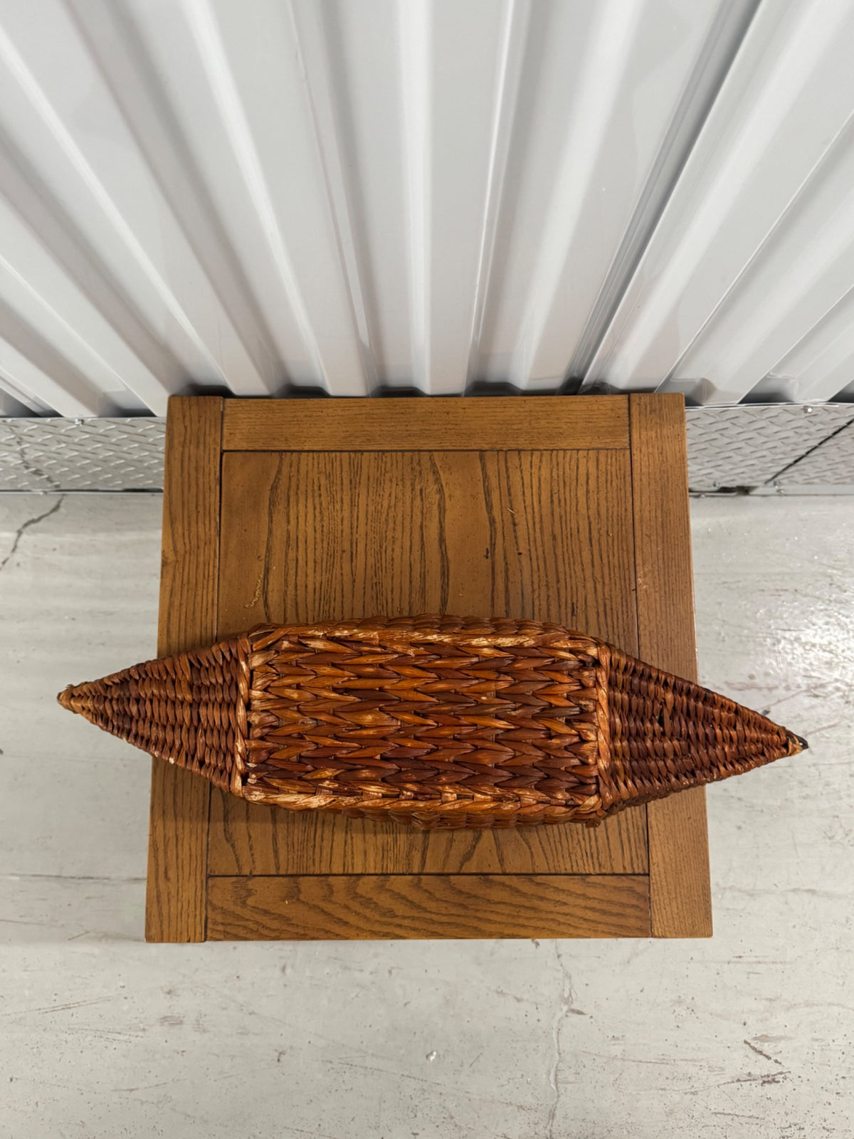 Wooden stand with wicker basket planter viewed from above, showing top and shelf