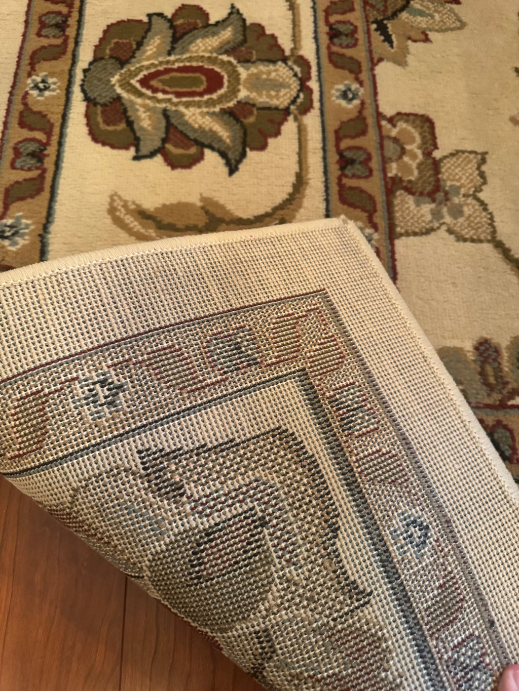 Underside of the rug folded back showing woven cotton backing