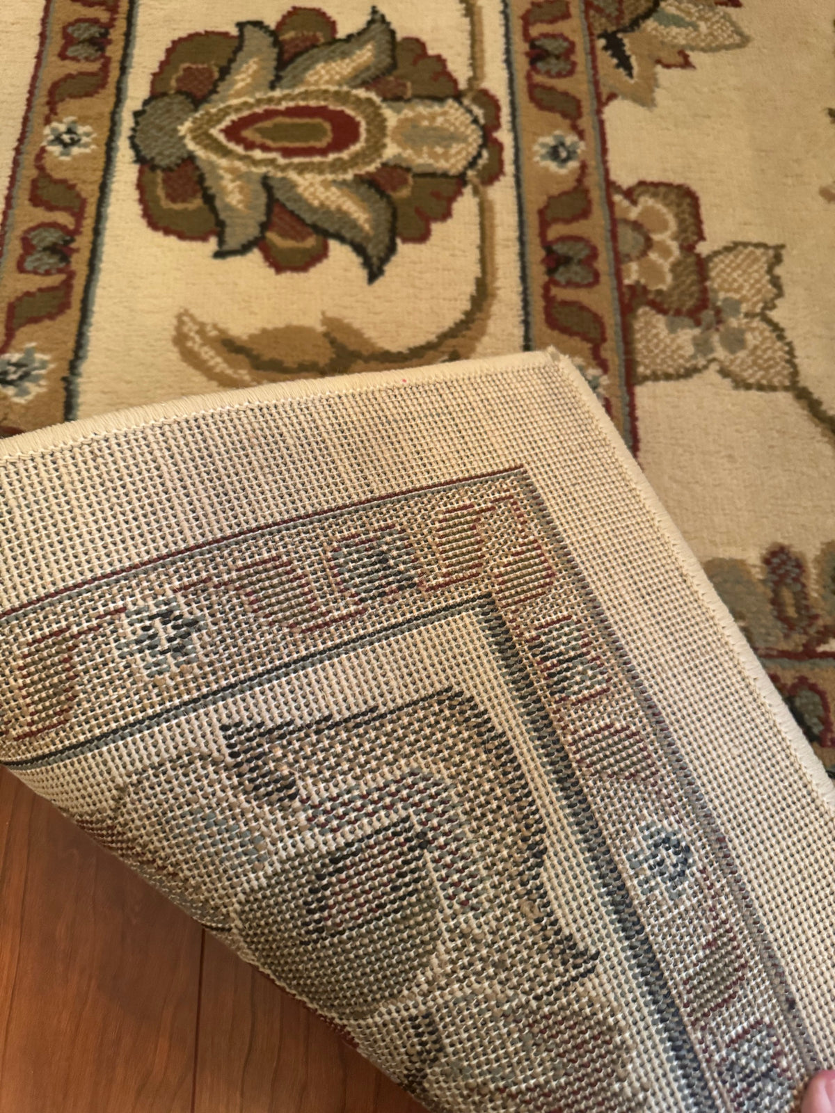 Underside of the rug folded back showing woven cotton backing