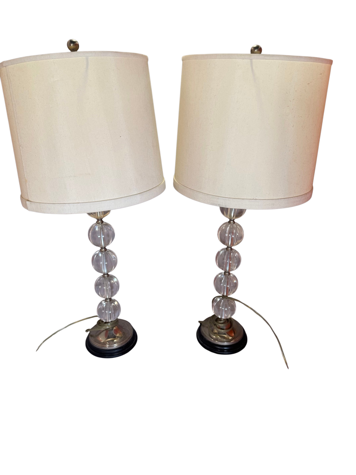 Pair of tall table lamps with clear ball stems and off-white drum shades, front view