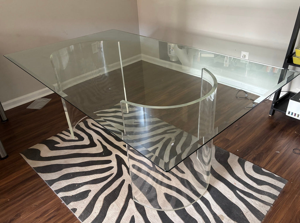 Glass dining table showing the curved acrylic pedestal