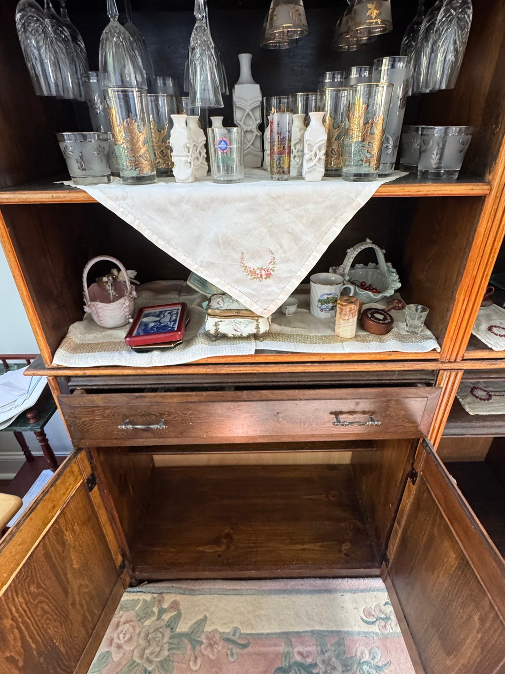 Open drawer area and shelf with glassware on top of the wall unit