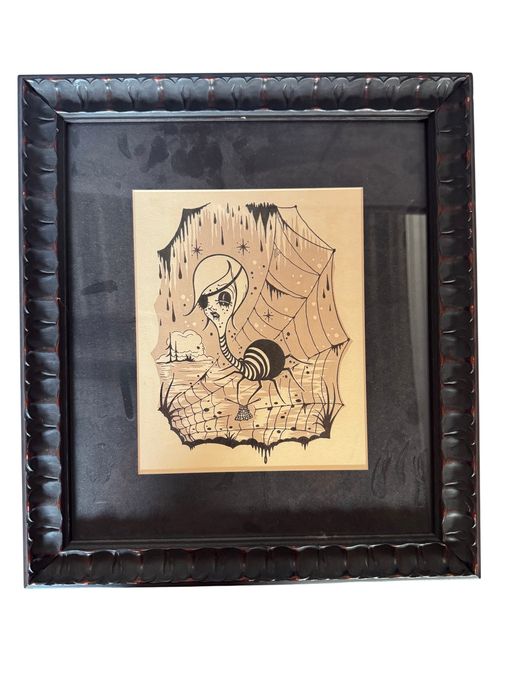 Framed artwork of a girl with an eyepatch and a spider web, straight-on