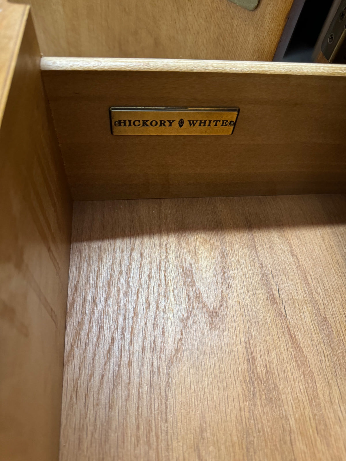 Interior drawer detail showing scalloped wooden pulls and three graduated drawers