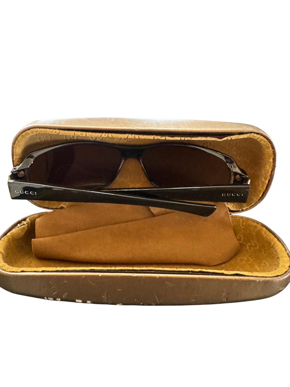 Gucci sunglasses with black frames and dark lenses in open tan velvet-lined case, showing interior view
